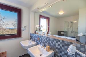 un bagno con due lavandini e un grande specchio di HIDDENSEE I mit Ostseeblick Haus Fore a Lohme