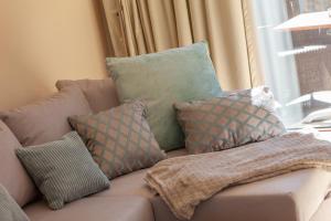 - un canapé avec des oreillers et une couverture dans l'établissement HIDDENSEE I mit Ostseeblick Haus Fore, à Lohme