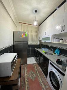 a small kitchen with a refrigerator and a sink at KK4 İMZAOĞLU 6 in Istanbul
