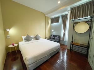 um quarto com uma grande cama branca num quarto em Tongsiam em Chiang Rai