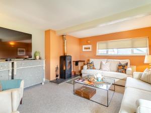 a living room with a couch and a fireplace at Oak Cottage in Saxmundham