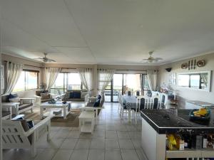 a kitchen and living room with white furniture and windows at Kangela 8A in Ponta Malongane