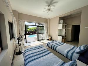 two beds in a bedroom with a view of a pool at Kangela 8A in Ponta Malongane