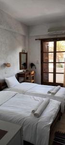 a bedroom with two beds with towels on them at Oinoi Hotel in Agios Kirykos