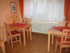 a dining room with two tables and chairs and a window at Gästehaus Kiesgen-Mendgen in Bernkastel-Kues