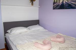 a bed with two pink slippers on top of it at Apartment Heart of Bjelovar in Bjelovar