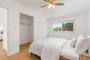a white bedroom with a bed and a window at Modern 4 King Beds, Beautiful Large Backyard, Golf, WFH, Long Stays, WI-FI, FWY, 25 mins to Beach in Casa Conejo