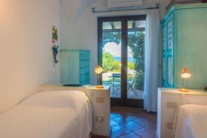 um quarto com 2 camas e uma porta para um pátio em Villa Baia - Porto Rafael em Palau