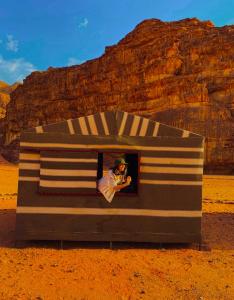 a person is taking a picture in a box in the desert at Wadi Rum Meteor camp in Wadi Rum