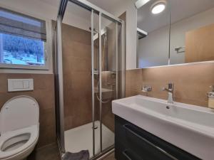 a bathroom with a toilet and a sink and a shower at Luxury Apartment Romaine 1st floor in Saas-Fee +12 photos