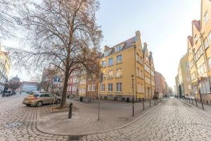 a cobblestone street in a city with buildings at Hello Apartments Double Loft in Gdańsk