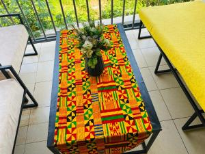 uma mesa com um vaso de flores em F&H 2 Bedroom cozy - Kigali apartment unit em Kigali