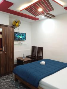 a bedroom with a bed with a blue blanket on it at Leo's Residency Coorg in Kushālnagar