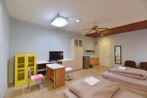 a room with two beds and a desk and a tv at 97 Merryland Apartments & Hotel in Ban Bang Samak