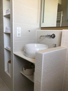Un baño con un lavabo blanco y un espejo. en Face à la mer, bel appartement, en Saint-Nazaire 15 fotos más