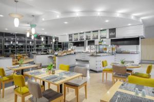 um restaurante com mesas e cadeiras e uma cozinha em INNSiDE by Meliá München Neue Messe em Munique