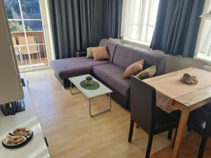 a living room with a purple couch and a table at Apartment Silvretta 