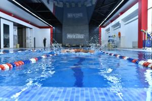 a person swimming in a swimming pool at Dora Hotel in Shymkent