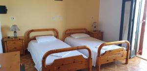 a bedroom with two beds and two night stands at SUNSET BAY STUDIOS in Agios Georgios