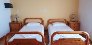 two twin beds in a room with two dressers at SUNSET BAY STUDIOS in Agios Georgios +8 photos