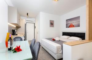 Cet appartement comprend une chambre avec un lit et une table ainsi qu'une cuisine. dans l'établissement TwinStars Superior Apartment, à Gerakini