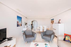 a living room with two chairs and a table at 2207-Modern apt with terrace and amazing seaview in Casares
