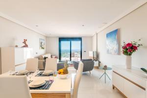 カサーレスにある2207-Modern apt with terrace and amazing seaviewのキッチン、リビングルーム(テーブル、椅子付)