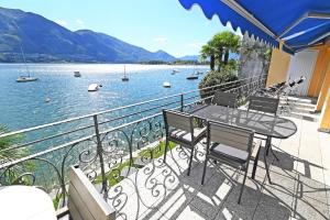 balkon ze stołem i krzesłami oraz widokiem na jezioro w obiekcie Villa Genovese al Lago w mieście Minusio