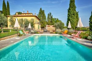basen z leżakami i parasolami przed domem w obiekcie Villa Maria w mieście Monte San Savino