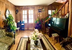 Guesthouse Georgia في Sagarejo: غرفة معيشة مع أريكة وبيانو