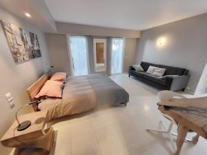 a bedroom with a large bed and a couch at Villa lours in Le Trayas