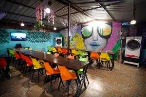 a dining room with a long table and colorful chairs at Creek Forest - Riverside Boutique Resort in Rishīkesh