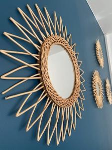 a mirror on a blue wall with a rattan sunburst at Hôtel Saint Roch Montpellier Centre in Montpellier
