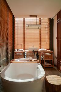 een groot bad in een kamer met een tafel bij Uin Oriental Hotel in Wuxi