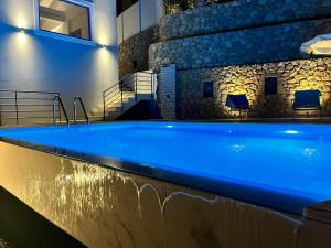 a large swimming pool in a building with blue lighting at Katerina's Village Agios Nikitas in Agios Nikitas