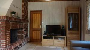 ein Wohnzimmer mit einem Kamin und einem TV in der Unterkunft Ferienhaus Becker in Bispingen