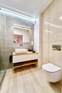 een badkamer met een wit toilet en een wastafel bij ApartFonte - Mickiewicza 2A - garaż podziemny in Polanica-Zdrój