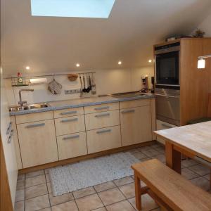 a kitchen with white cabinets and a sink and a table at Ferienwohnung Holzmaier in Bad Aibling