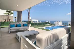 un patio con sofá, mesa y piscina en 2254-Luxury villa with private pool and seaview en Sotogrande