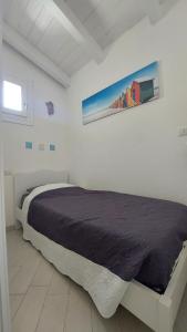 1 dormitorio con 1 cama con una pintura en la pared en Cala Sardinia Apartment, en Viddalba