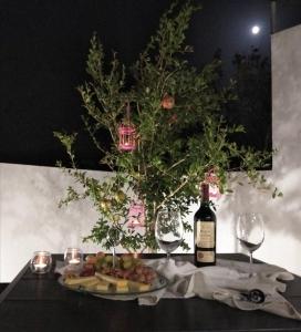 a table with a bottle of wine and a plate of food at Arismari Apartments in Zíros