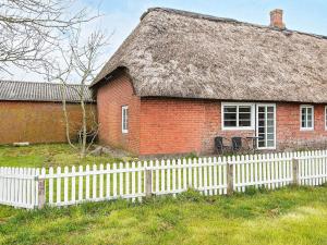 an old brick house with a white picket fence at 6 person holiday home in H jer in Højer
