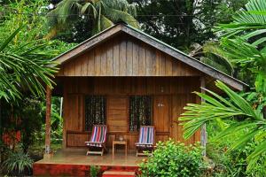 two chairs and a table in front of a building at PRISTINE BEACH RESORT in Diglipur