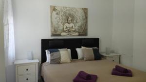 a bedroom with a bed with a picture on the wall at Casa Patricia, Ladera del Mar, Nerja in Nerja
