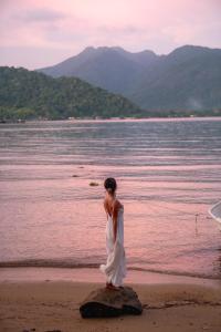 a woman in a white dress standing on the beach at Resolution Resort in Ko Chang