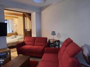 - un salon avec un canapé rouge et un lit dans l'établissement Urlaub im Friseursalon, à Sebnitz