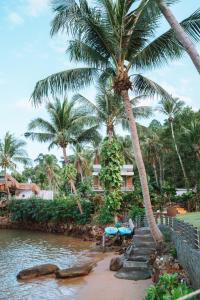 a resort with palm trees next to a body of water at Resolution Resort in Ko Chang