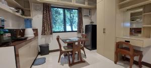 cocina con mesa, sillas y ventana en Le Chateau Residences, en Bacolod