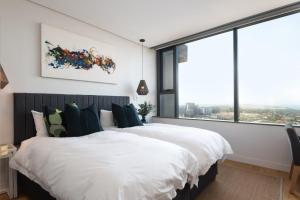een slaapkamer met een groot bed en grote ramen bij Umhlanga Arch, Luxury Sea View Apartment in Durban