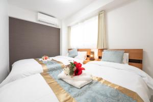 大阪市にあるGN98 Saiwaicho Osakのベッドルーム1室(花の飾られたベッド2台付)